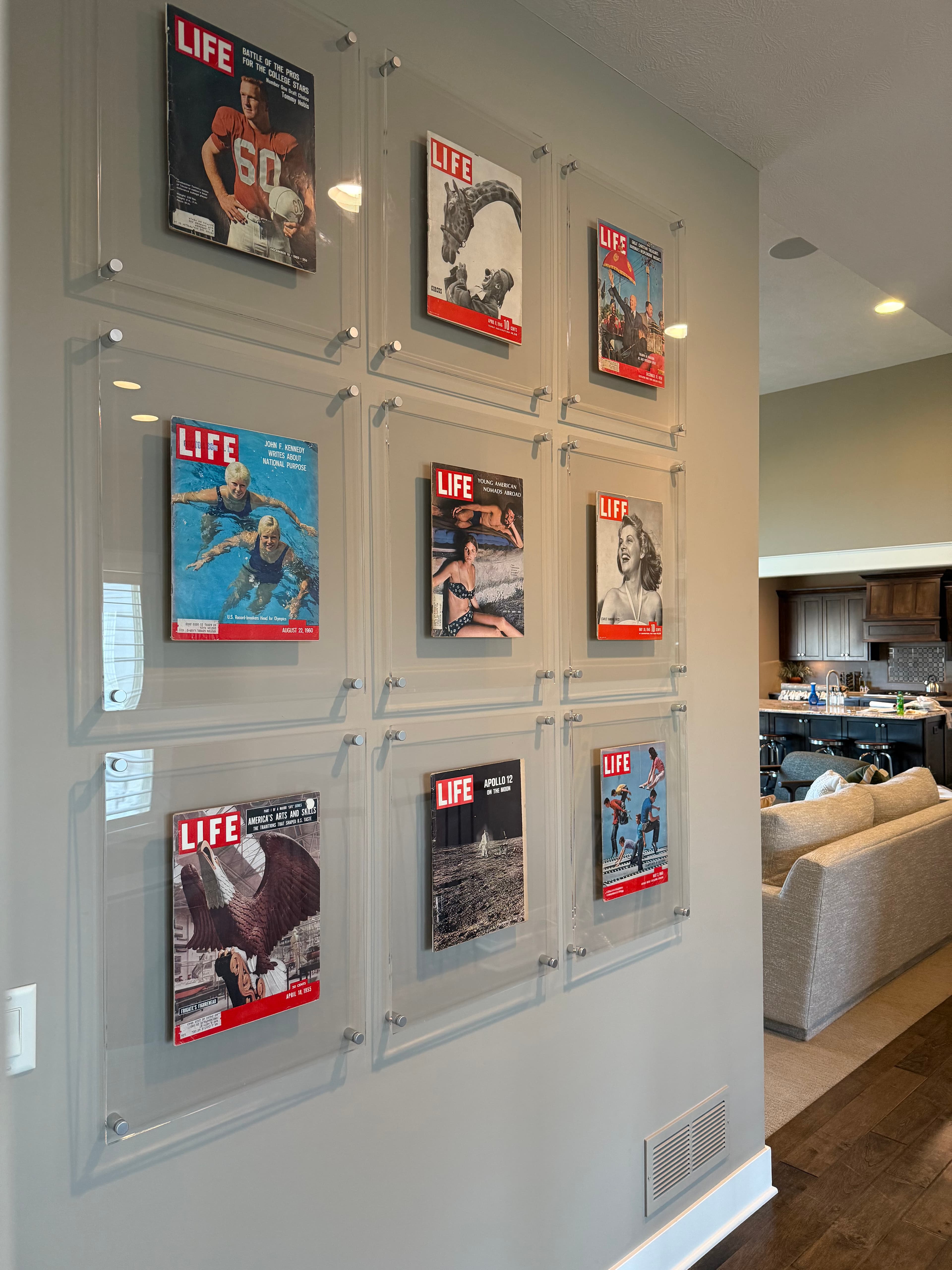 Nine vintage LIFE magazine covers mounted in acrylic frames on a wall